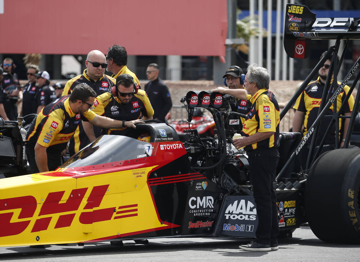 Crew members of Top Fuel driver Shawn Langdon prepare for the first round of Top Fuel eliminati ...