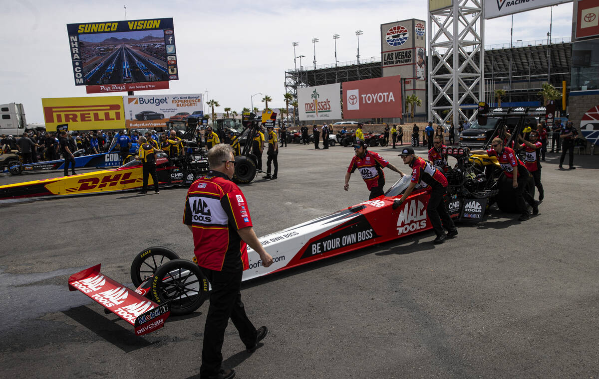 Crew members for Top Fuel driver Doug Kalitta roll him out during the first round of Top Fuel e ...