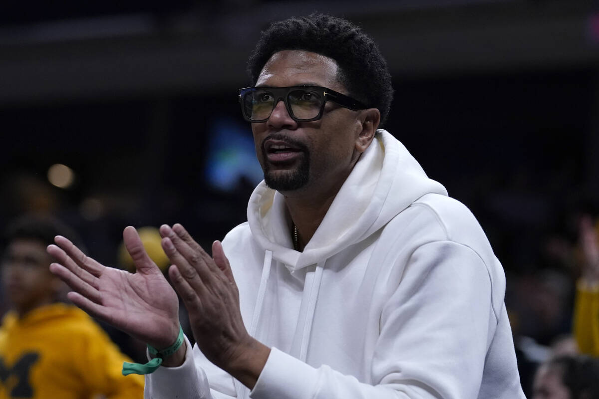 Former Michigan player Jalen Rose watches during the first half of a college basketball game be ...