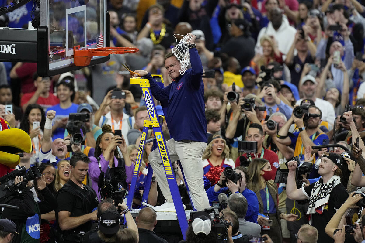 Kansas head coach Bill Self holds the net after a college basketball game in the finals of the ...