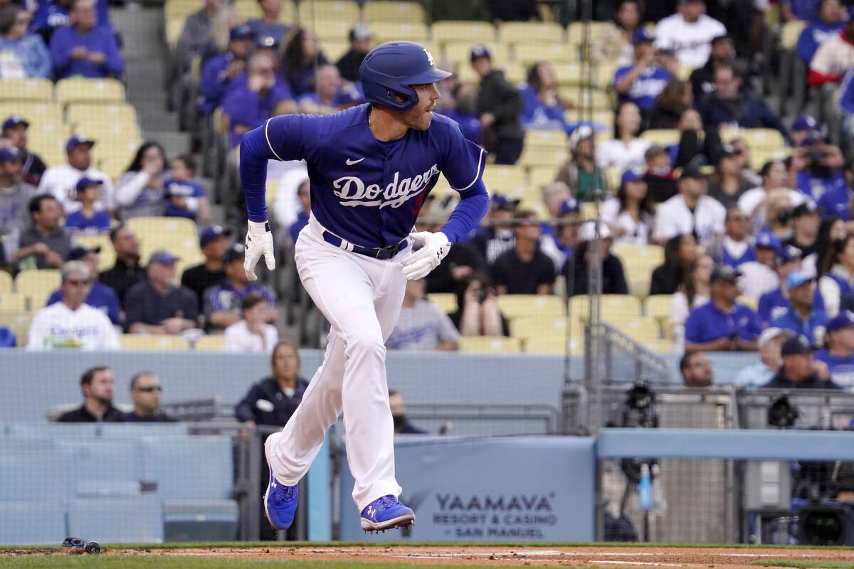 Los Angeles Dodgers' Freddie Freeman heads to first as he hits a triple during the first inning ...