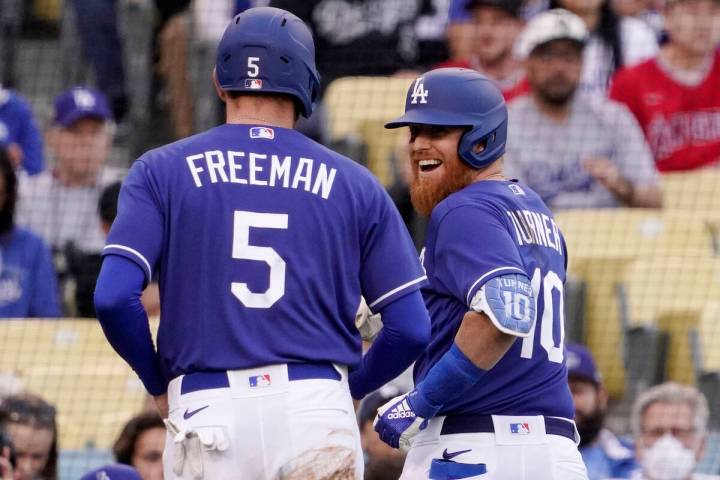 Los Angeles Dodgers' Justin Turner, right, smiles at Freddie Freeman after he hit a sacrifice f ...