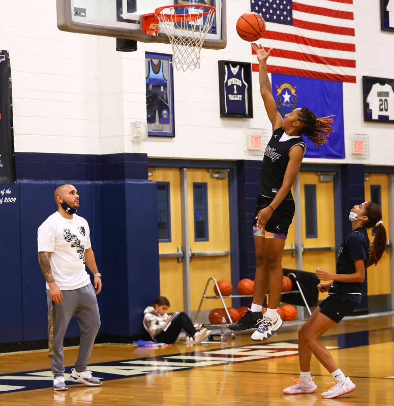 Spring ValleyÕs Aaliyah Gayles lays up the ball as coach Billy Hemberger, left, looks on ...