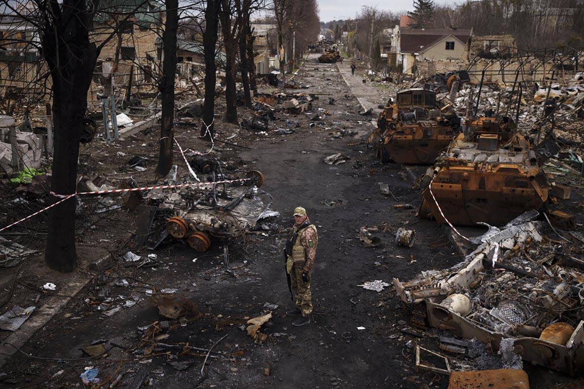 A Ukrainian serviceman stands amid destroyed Russian tanks in Bucha, on the outskirts of Kyiv, ...