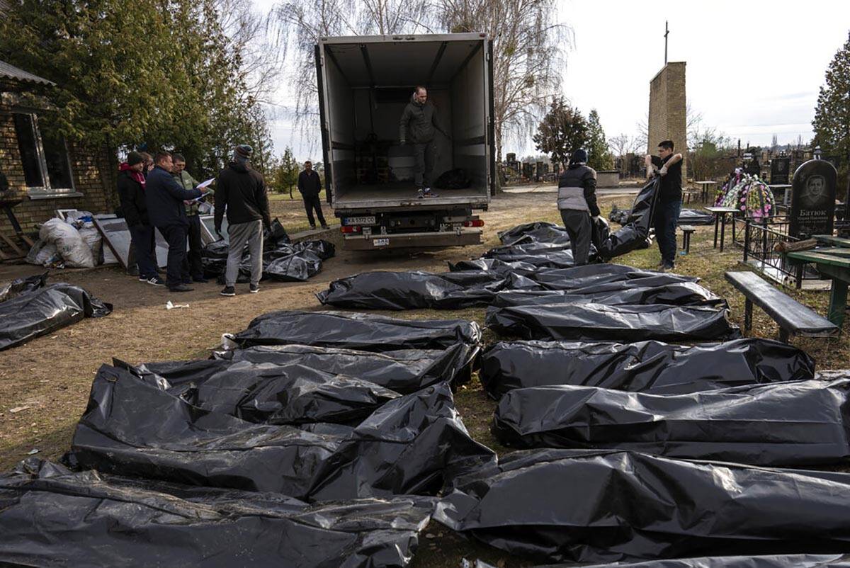 Cemetery workers load the corpses of civilians killed in Bucha into a truck, to be transported ...