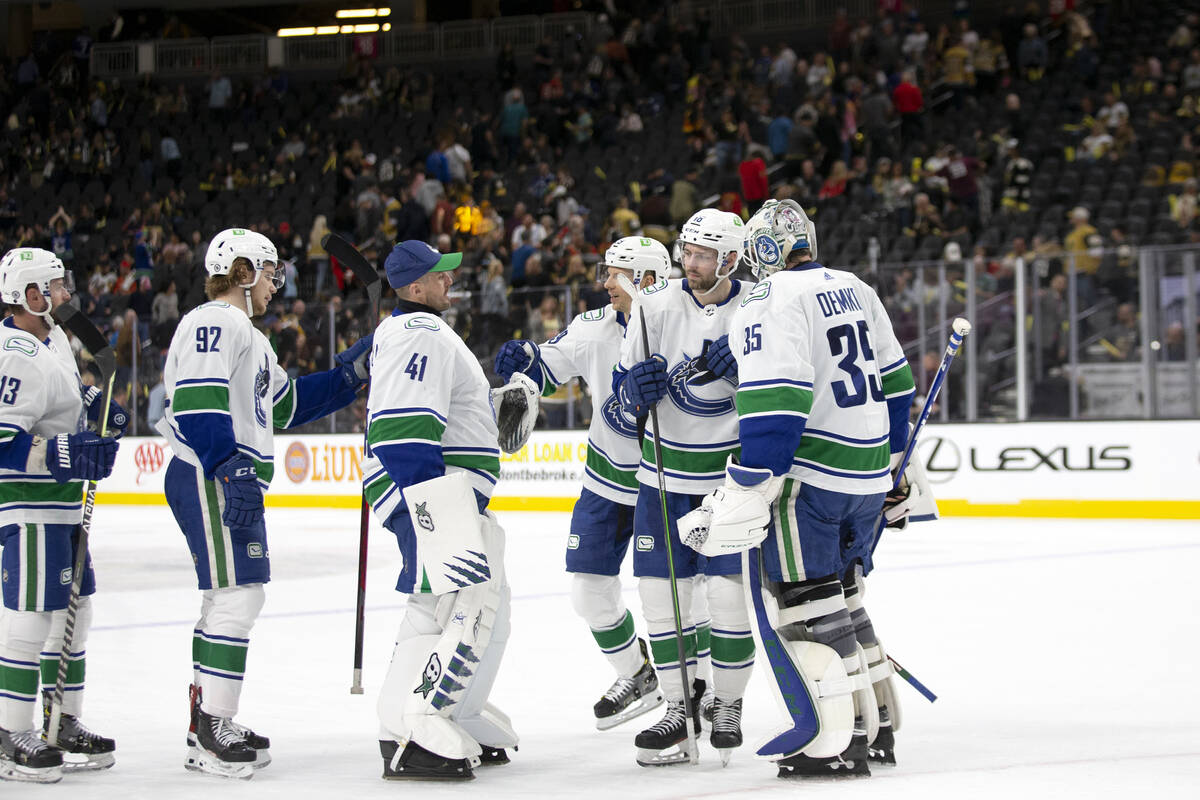 The Canucks congratulate each other and goaltender Thatcher Demko (35) after winning an NHL hoc ...