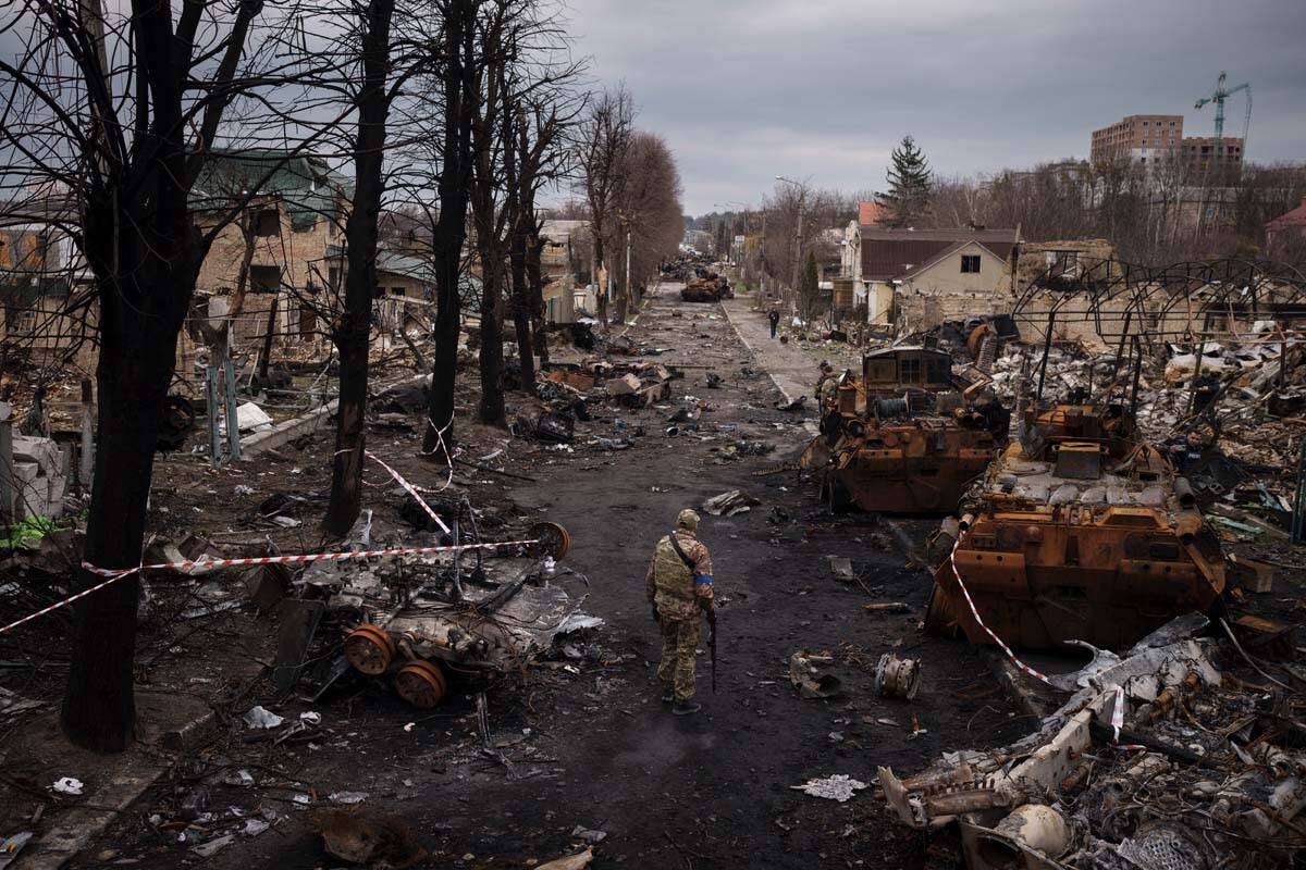 A Ukrainian serviceman walks amid destroyed Russian tanks in Bucha, on the outskirts of Kyiv, U ...