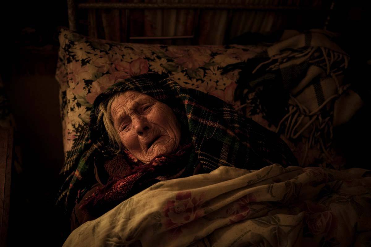 Motria Oleksiienko, 99 years-old, traumatized by the Russian occupation, lies in her bed in a r ...