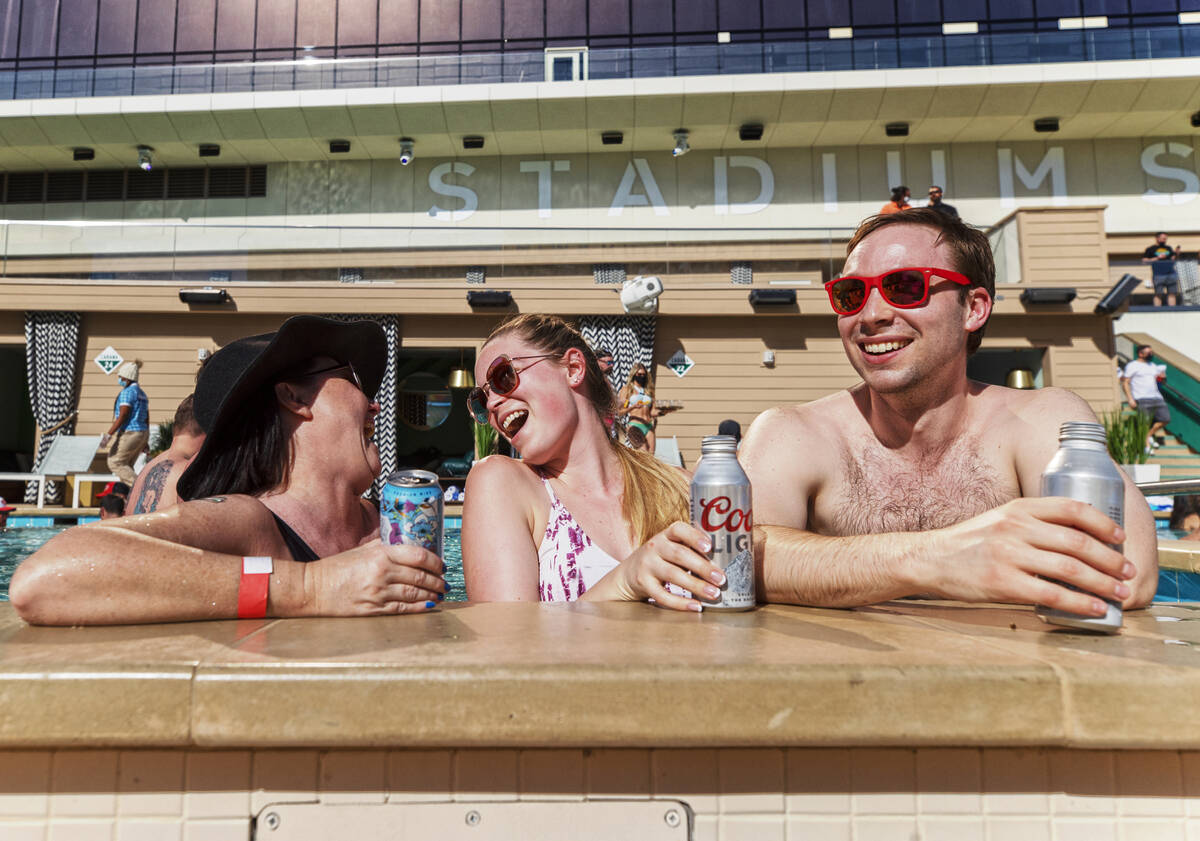 Stacy Sheridan, left, Katie Hatfield and Tom Rollag, from Minneapolis, Minn., enjoy the pool at ...