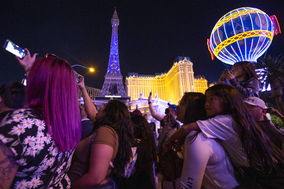 BTS fans watch as the Bellagio Fountain plays a show to songs “Butter” and ȁ ...
