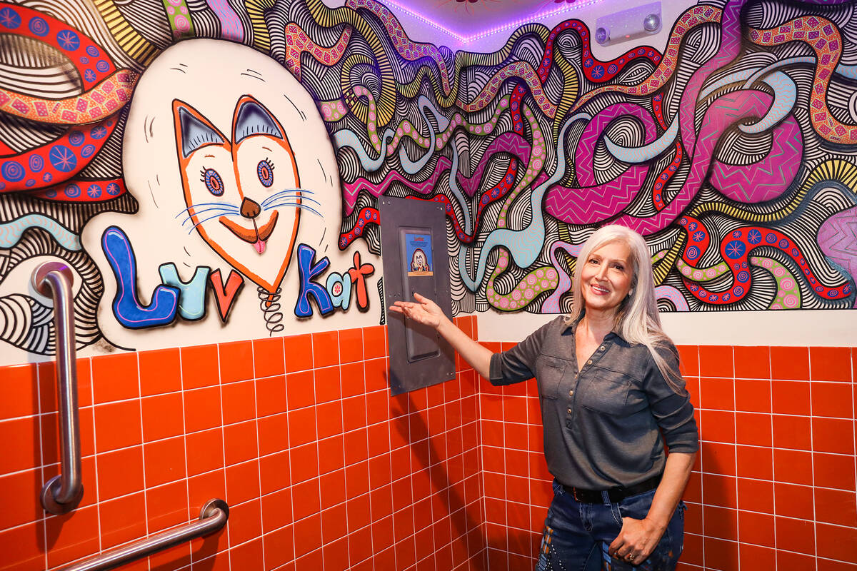 Artist Nancy Good points out her work in one of the bathrooms at Square Bar, a 70’s themed ba ...