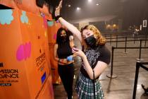Jennifer Angelo of Las Vegas gets a photo card of a BTS band member during BTS LIVE PLAY at MGM ...