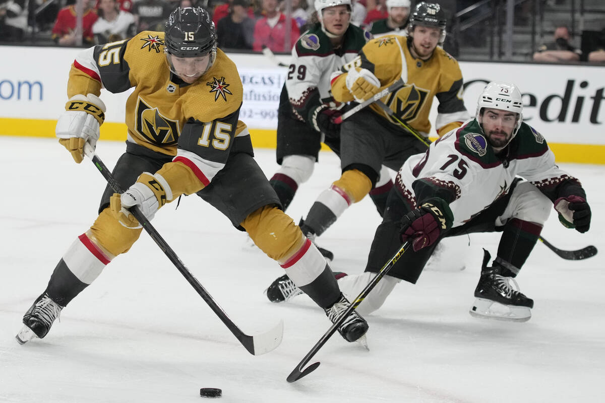 Vegas Golden Knights center Jake Leschyshyn (15) skates around Arizona Coyotes defenseman Kyle ...