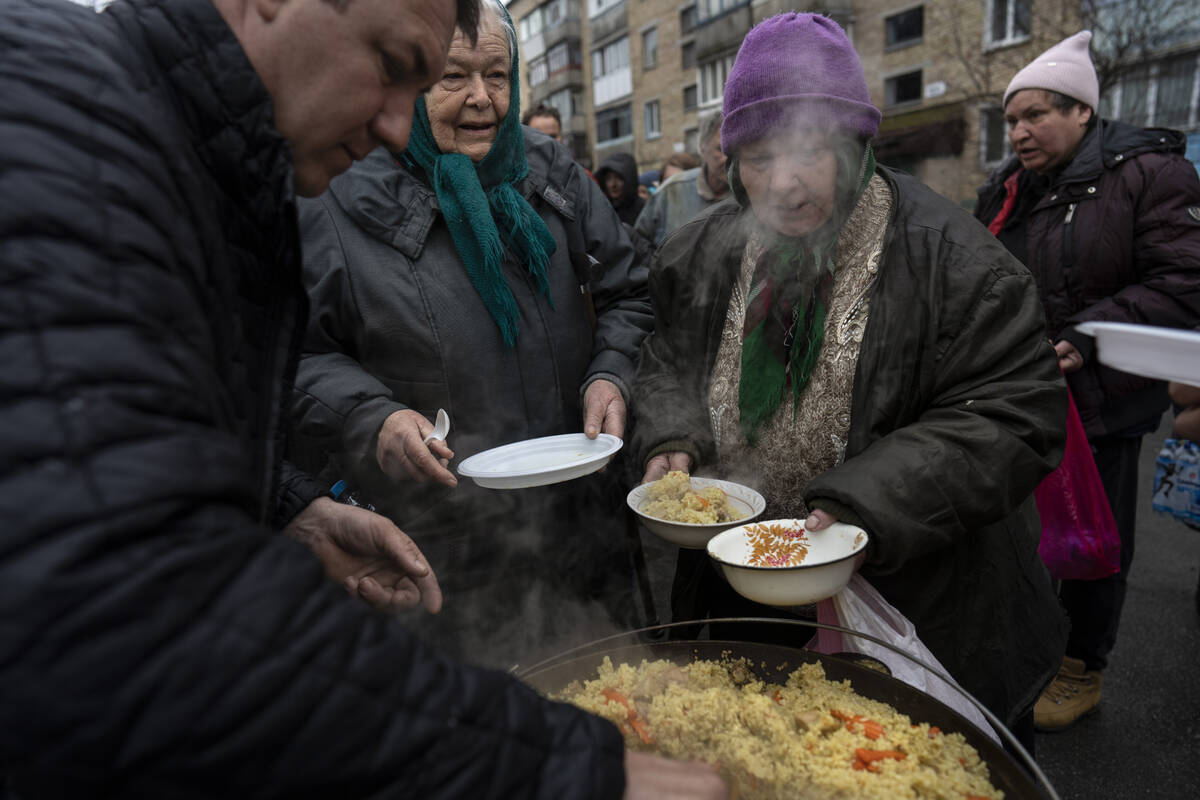 Neighbours receive free food from a soup kitchen in Bucha, in the outskirts of Kyiv, Ukraine, S ...