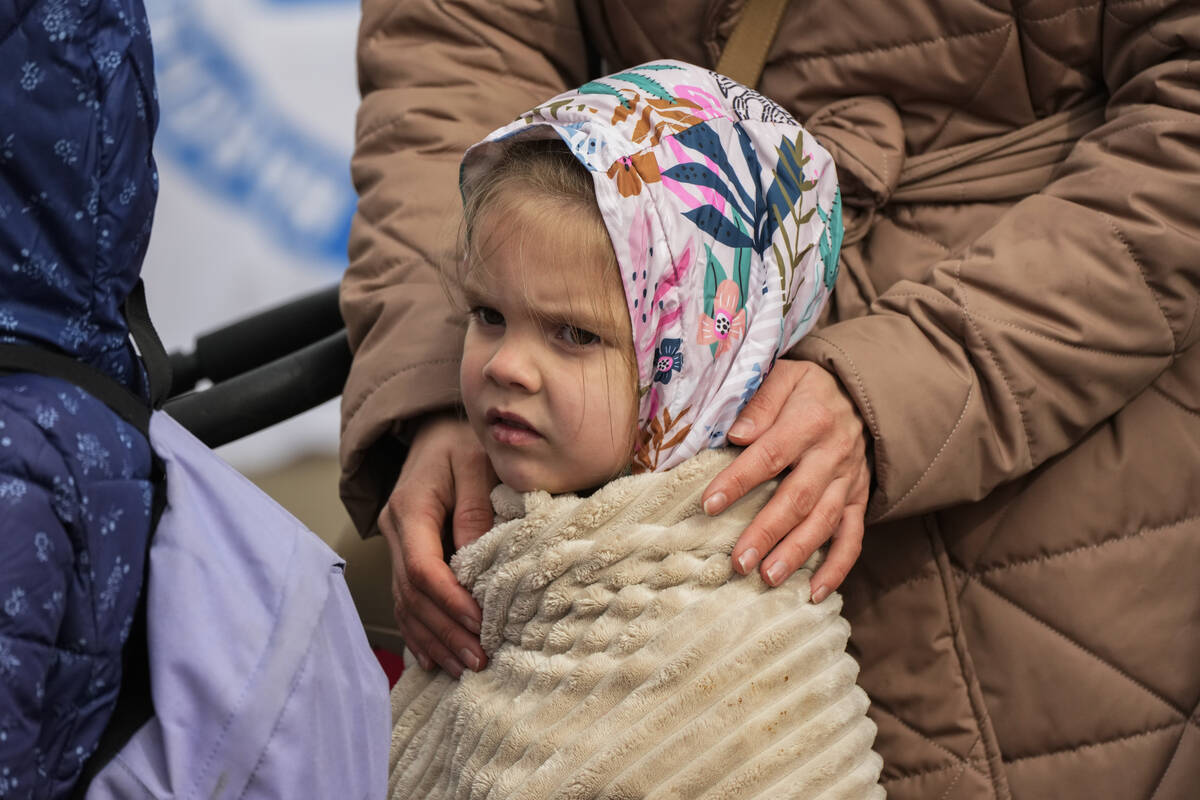 A refugee child waits in a line after fleeing the war from neighboring Ukraine at the border cr ...