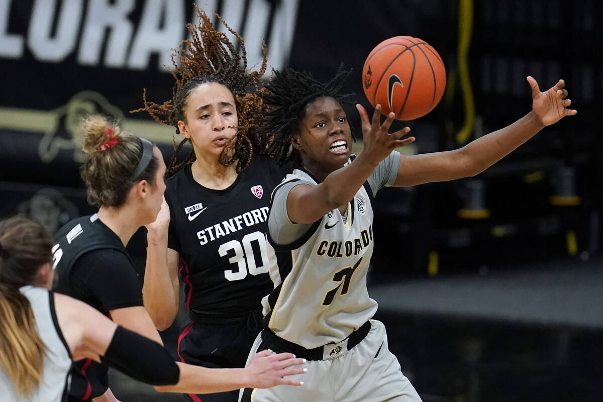 Colorado guard Mya Hollingshed, right, pulls in a rebound as Stanford guards Lexie Hull, left, ...