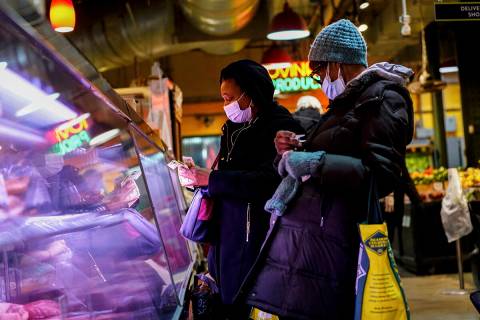 Customers wearing face masks to protect against the spread of the coronavirus shop at the Readi ...