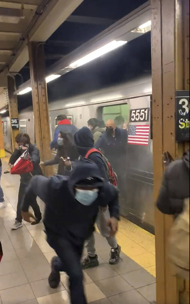 In this photo from social media video, passengers run from a subway car in a station in the Bro ...