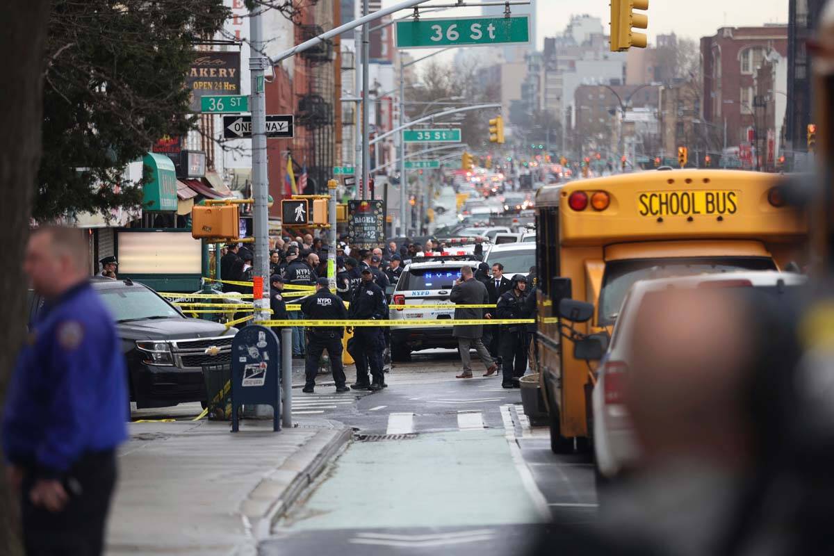 Law enforcement gather near the entrance to a subway stop in the Brooklyn borough of New York, ...