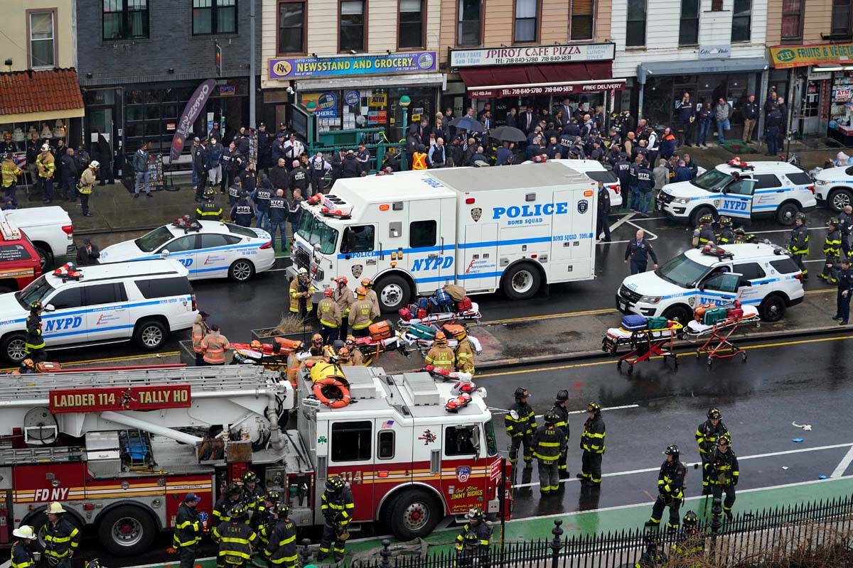 Emergency personnel gather at the entrance to a subway stop in the Brooklyn borough of New York ...