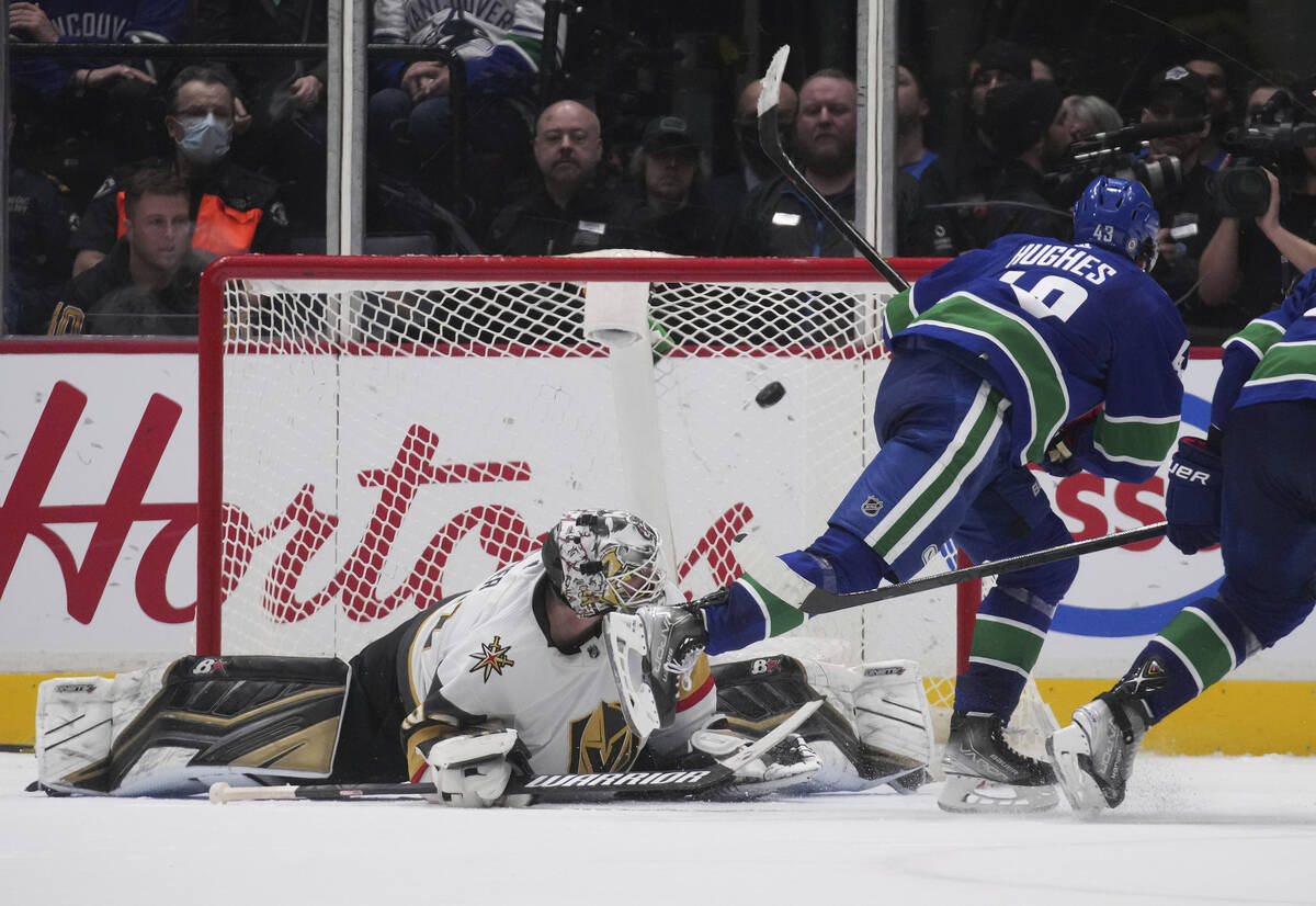 Vancouver Canucks' Quinn Hughes, right, scores against Vegas Golden Knights goalie Robin Lehner ...