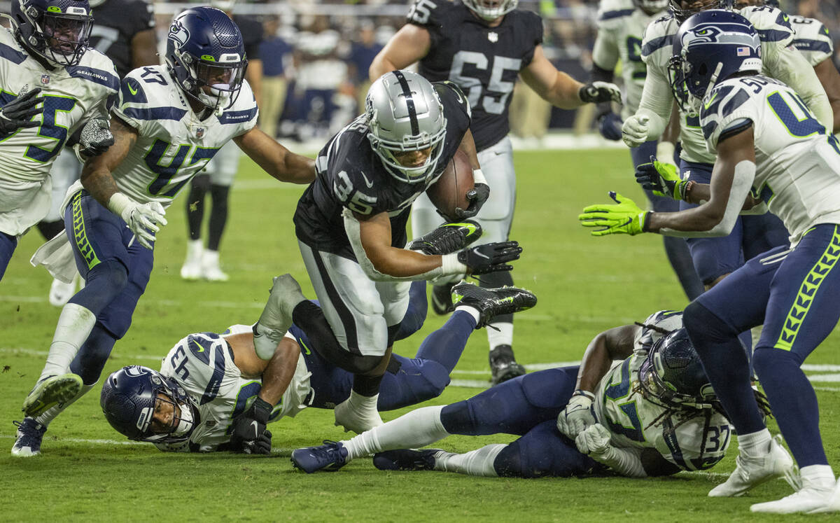 Raiders running back B.J. Emmons (35) breaks tackles by Seattle Seahawks linebacker Aaron Donko ...