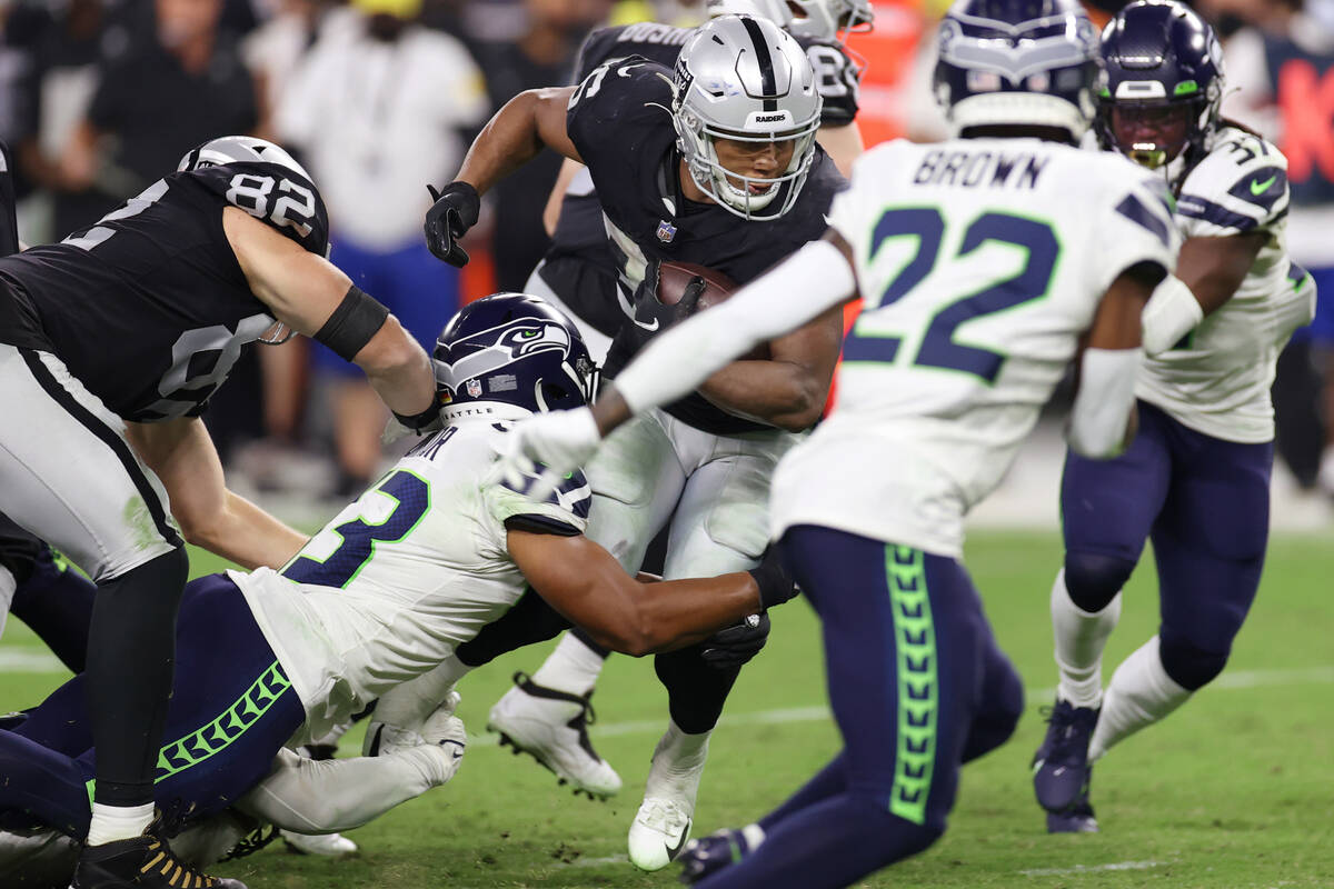 Las Vegas Raiders running back B.J. Emmons (35) is tackled by Seattle Seahawks linebacker Aaron ...