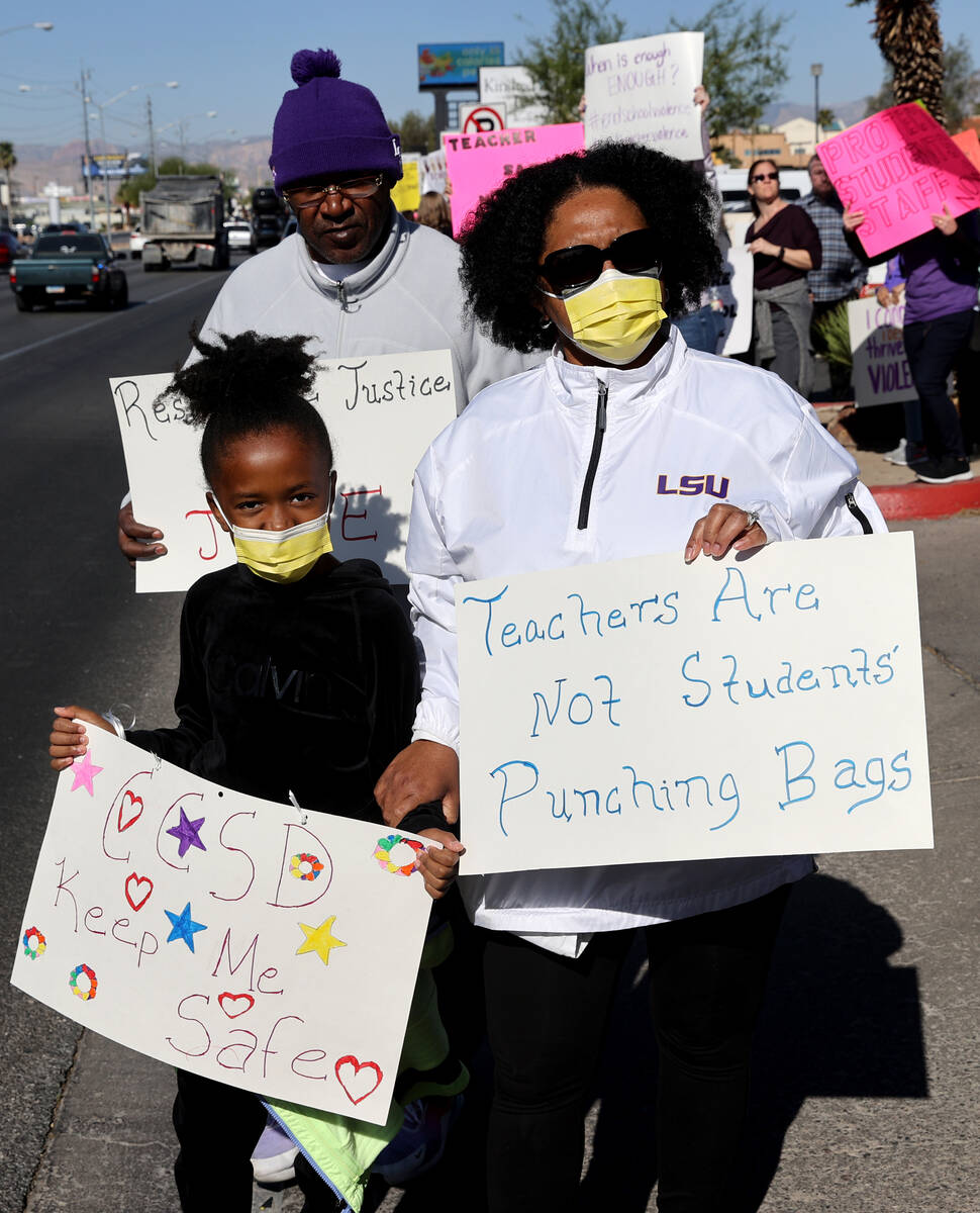 Kaitlyn Bass, 9, her father Alandre Bass and her mother who declined to give her name, protest ...