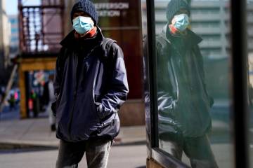 A person wearing a face masks to protect against the spread of the coronavirus walks in Philade ...