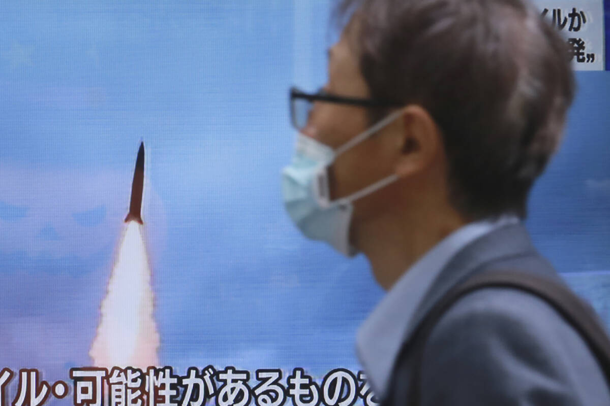 A man walks past a TV screen showing a news program reporting about North Korea's missile launc ...