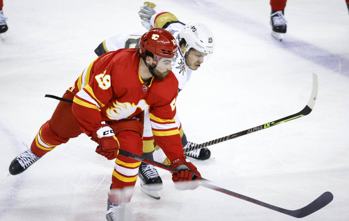 Vegas Golden Knights' Mattias Janmark, right, and Calgary Flames' Dillon Dube chase the puck du ...