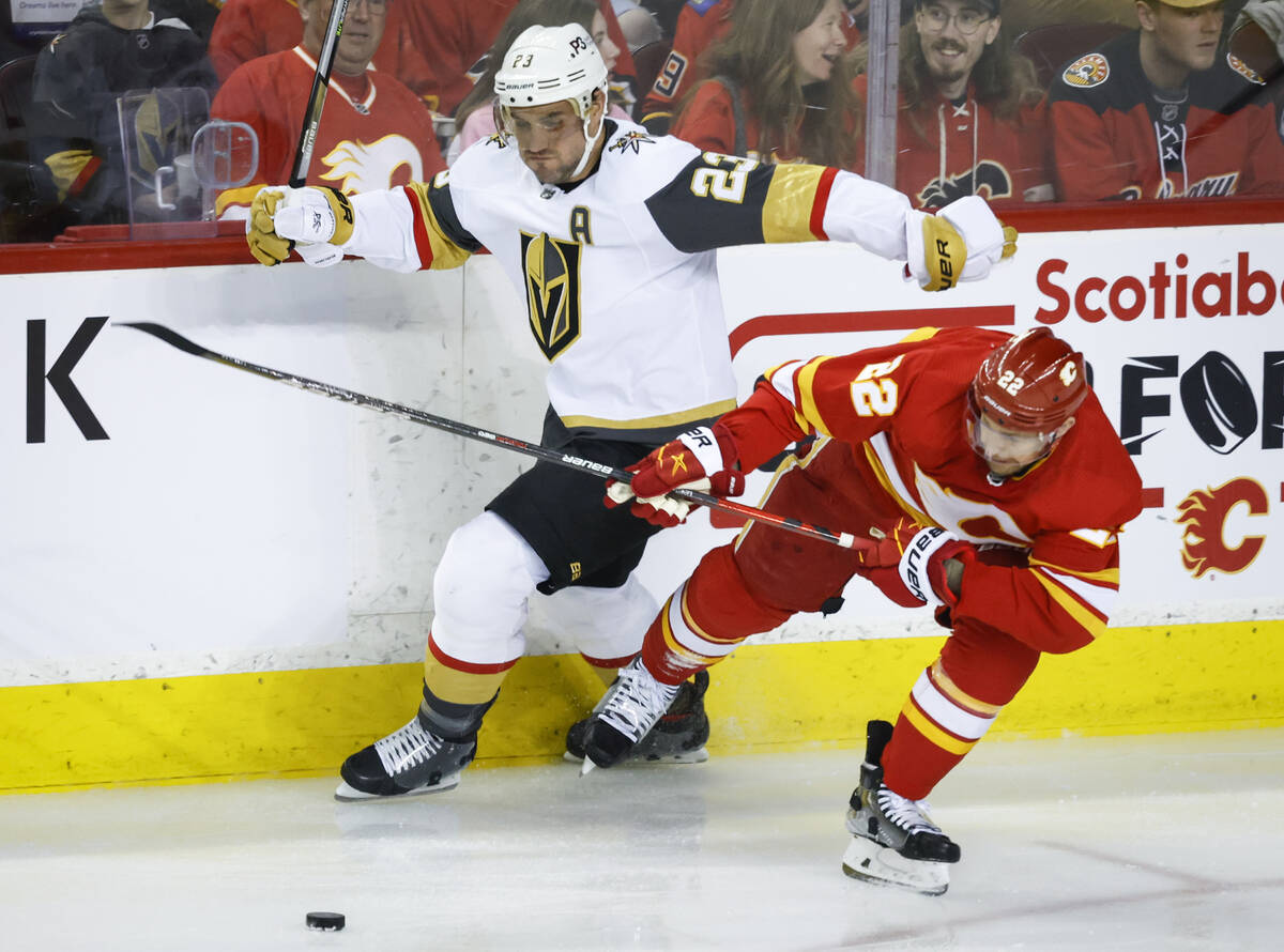 Vegas Golden Knights' Alec Martinez, left, checks Calgary Flames' Trevor Lewis during first-per ...