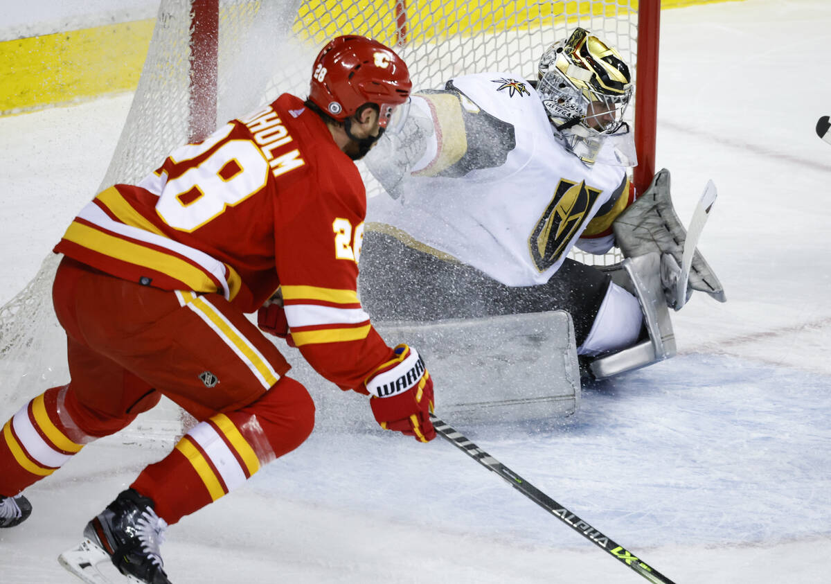 Vegas Golden Knights goalie Logan Thompson, right, blocks the net against Calgary Flames' Elias ...