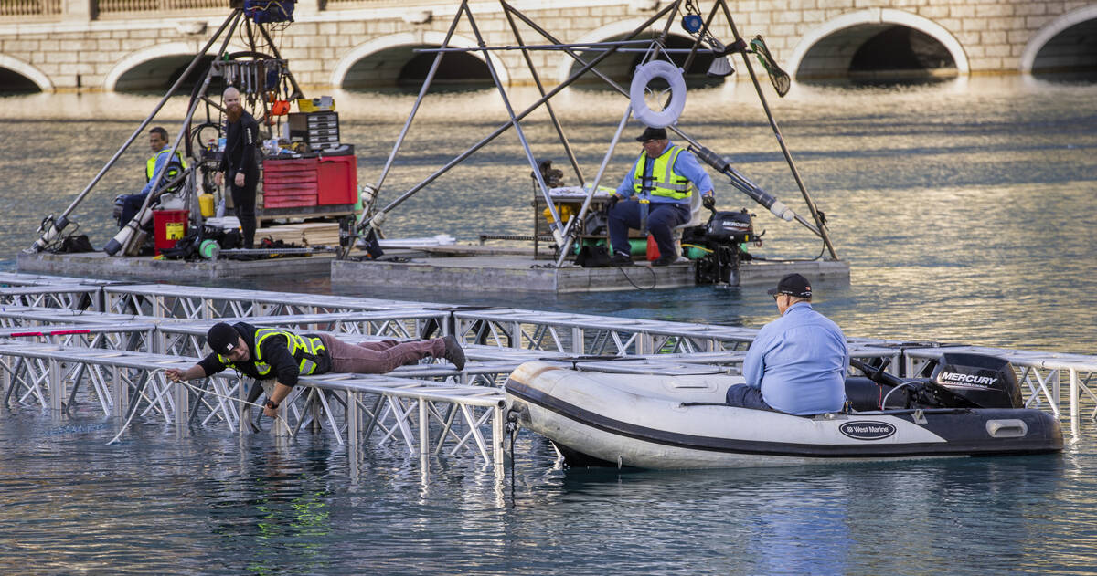 The first piece for the NFL Draft red carpet stage is secured onto stabilizers within the water ...