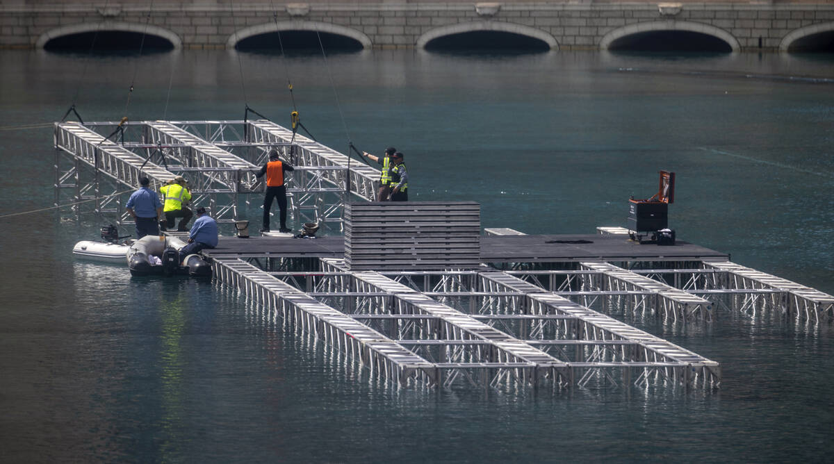A construction crew lowers another section for the NFL Draft red carpet stage stage towards the ...
