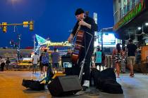 Street performer Jordan Polovina with the group Grim & Darling plays and electric cello wit ...