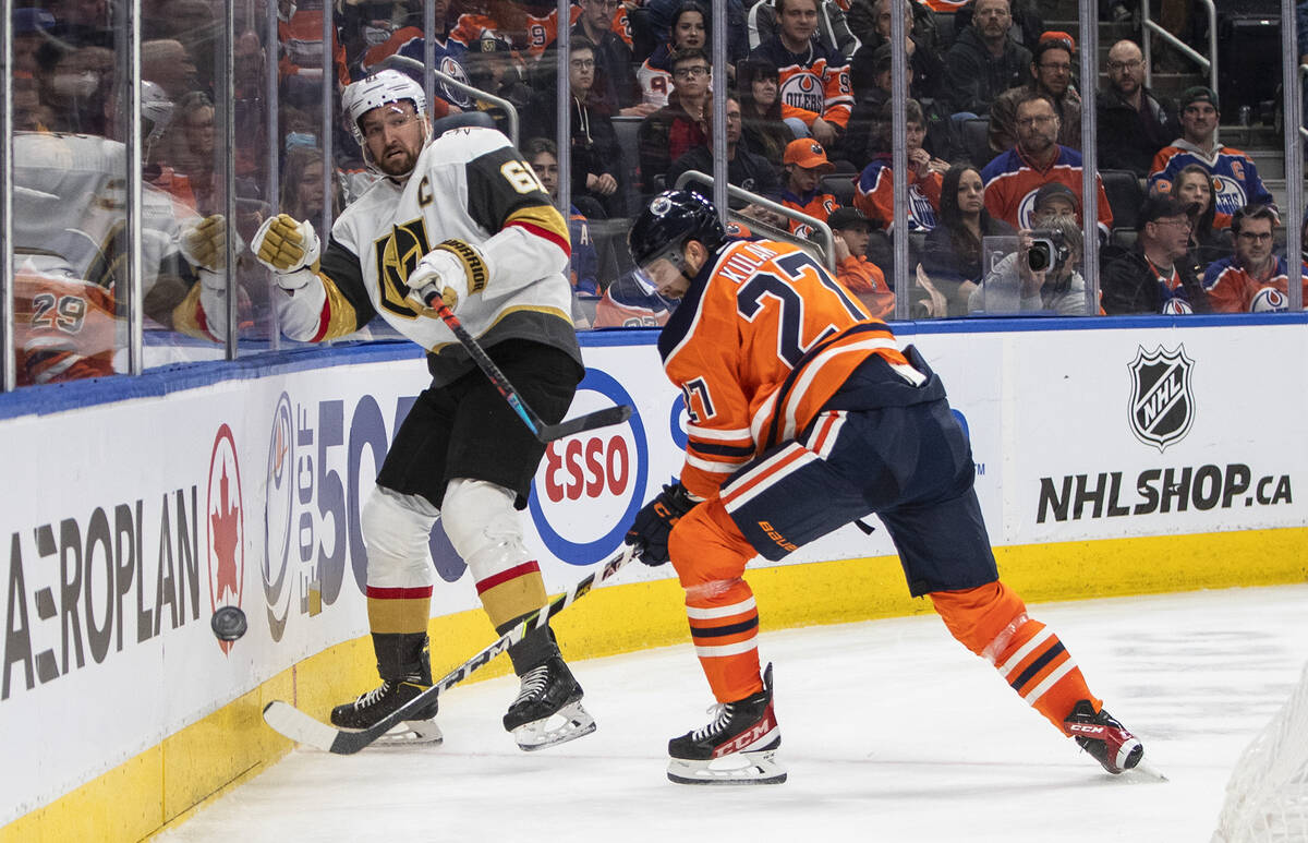Vegas Golden Knights' Mark Stone (61) and Edmonton Oilers' Brett Kulak (27) battle for the puck ...