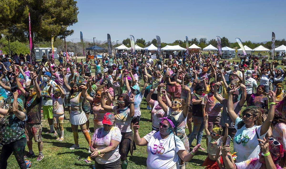 Participants follow a dancer on stage during the Holi Festival of Colors which features music, ...