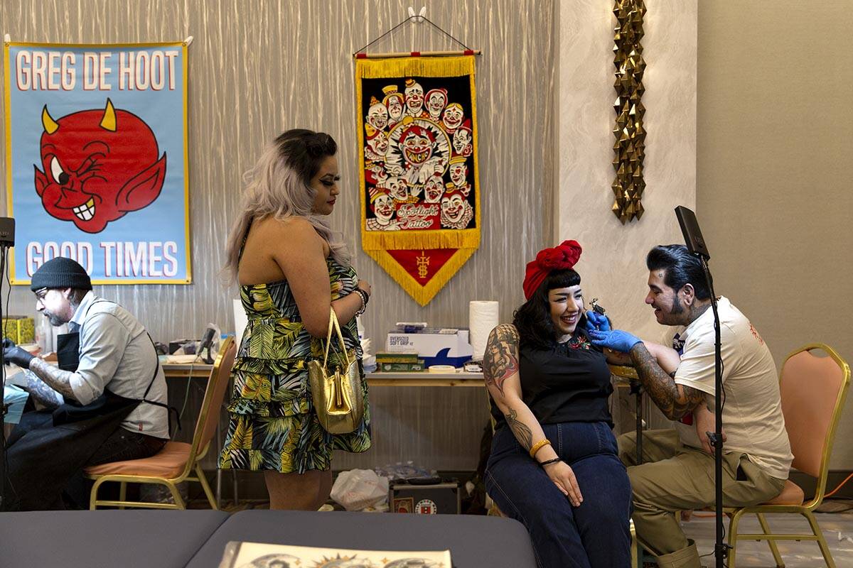 Carolina Franco, center right, has a clown tattooed on her by Pancho in the Tattoo Saloon durin ...