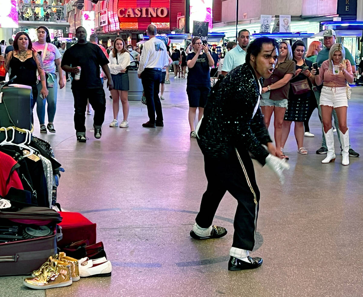 A street performer channels Michael Jackson while dancing for the crowd about a designated circ ...