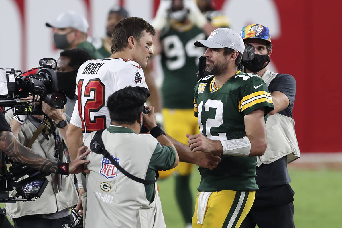 Tampa Bay Buccaneers quarterback Tom Brady, left, shakes hands with Green Bay Packers quarterba ...