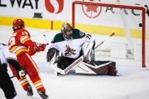 Arizona Coyotes goalie Karel Vejmelka, right, lets in a goal from Calgary Flames' Johnny Gaudre ...