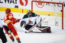 Arizona Coyotes goalie Karel Vejmelka, right, lets in a goal from Calgary Flames' Johnny Gaudre ...