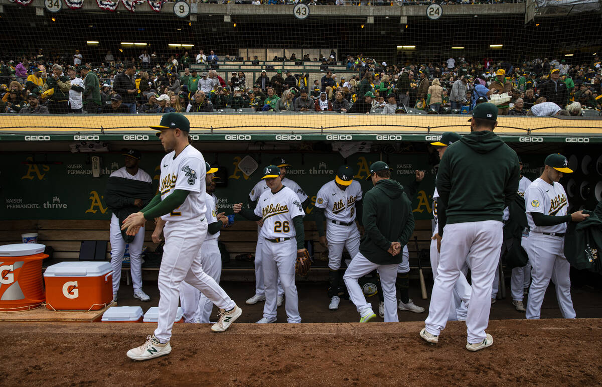 Oakland Athletics players gather in the dugout before the start of the opening night game again ...