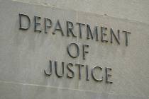 FILE - An exterior sign is photographed outside the Robert F. Kennedy Department of Justice bui ...