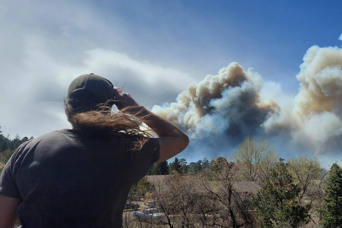 Smoke from a wind-whipped wildfire rises above neighborhoods on the outskirts of Flagstaff, Ari ...