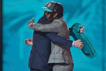 Alabama wide receiver Jaylen Waddle, right, hugs NFL Commissioner Roger Goodell after he was ch ...