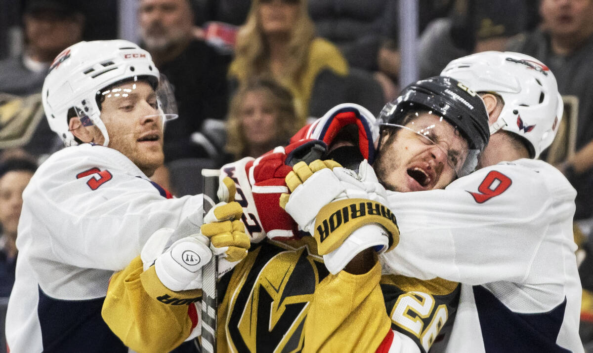 Golden Knights center Mattias Janmark (26) gets tied up with Washington Capitals defenseman Dmi ...