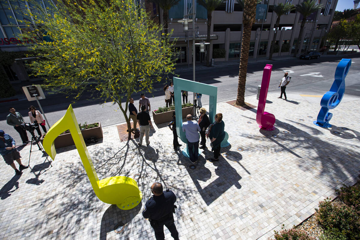 People gather arouind the "Larger Than Life" public art piece after it’s dedic ...