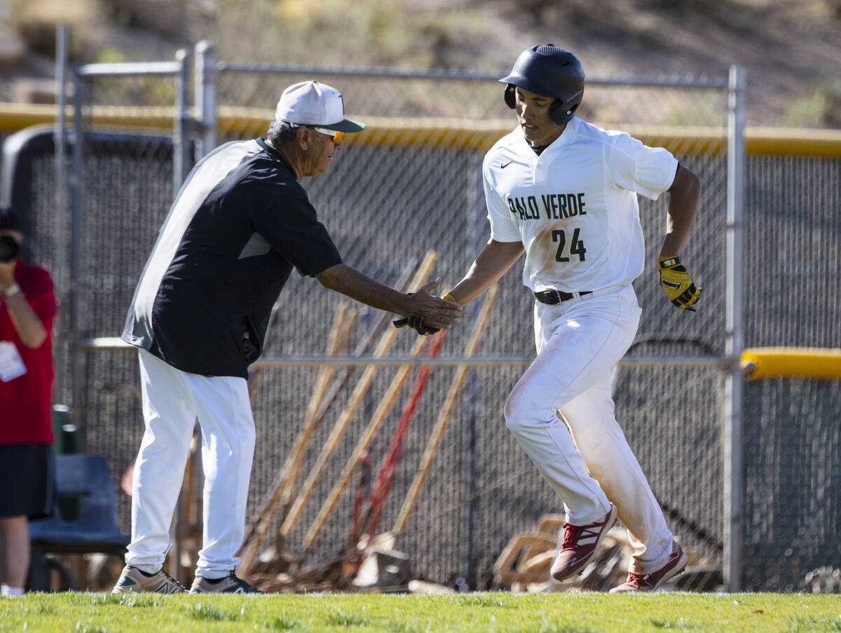 Palo High’s outfielder Kyle Williamson (24) congratulated by assistant coach Manny Abey ...